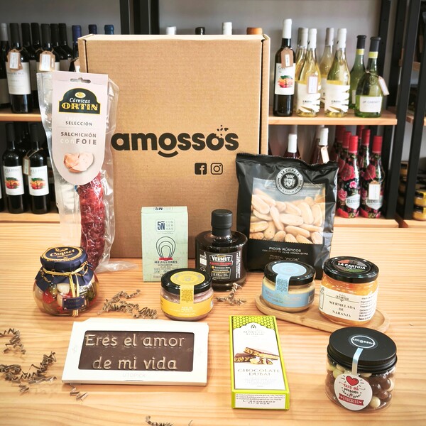 Caja gourmet Amossos con paté de perdiz, mermelada de naranja, crema de queso azul con trufa, vermut rojo mini, chocolate Dubai, salchichón con foie, picos rústicos, cacahuetes a los tres chocolates, cocktail de encurtidos, mejillones en escabeche y tableta de chocolate con mensaje “Eres el amor de mi vida”.