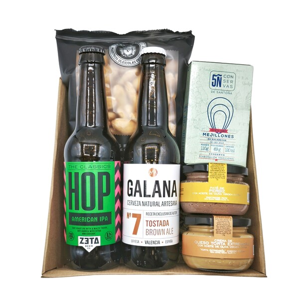 Cesta gourmet cervecera envuelta en celofán con cerveza IPA, cerveza Brown Ale, patés gourmet, mejillones en conserva y picos artesanos, lista para regalar.