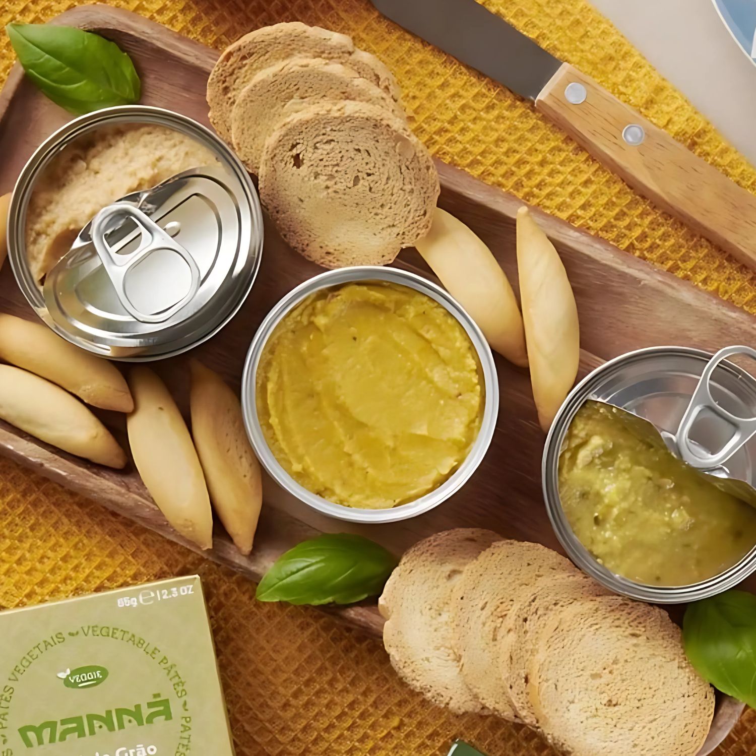 Tabla variada con envases de paté Manná, tostadas integrales y picos de pan listos para servir